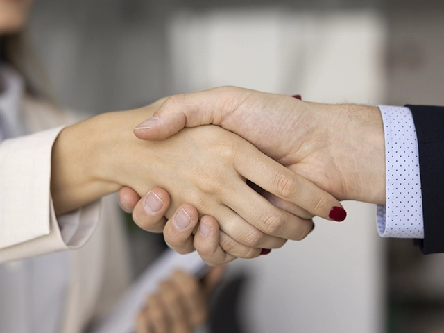 A handshake between a sponsor and a Phoenix Rising Foundation representative